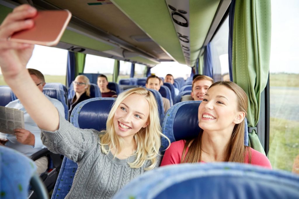 Mädchen in einem Reisbus, die ein Selfie machen